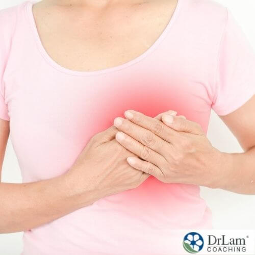 An image of a woman holding her breast that is red showing pain